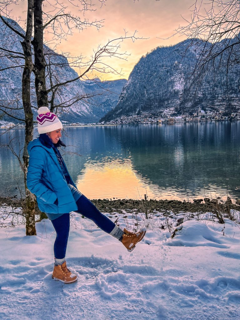 Kiki from RooKiExplorers playing with snow near the Hallstatt station's dock.