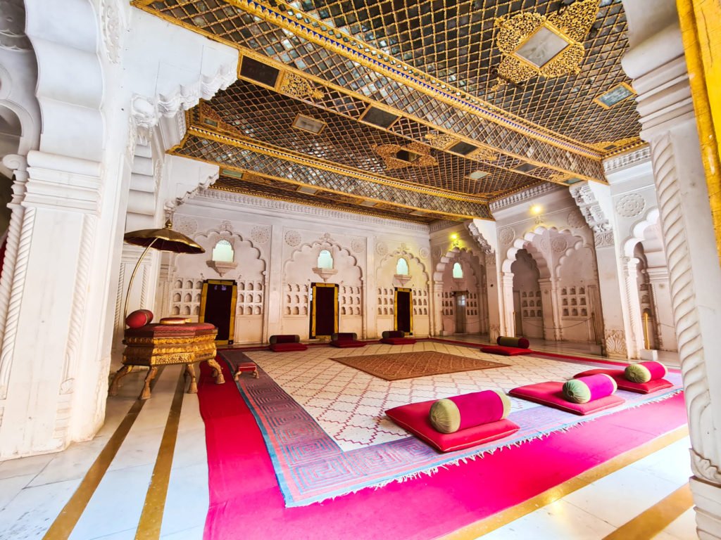 A room with a throne and a few seats in the Mehrangarh fort.