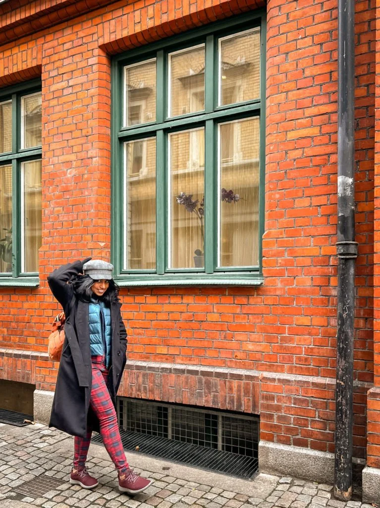 Kiki from RooKiExplorers walking in front of a building in Lilla Torg.