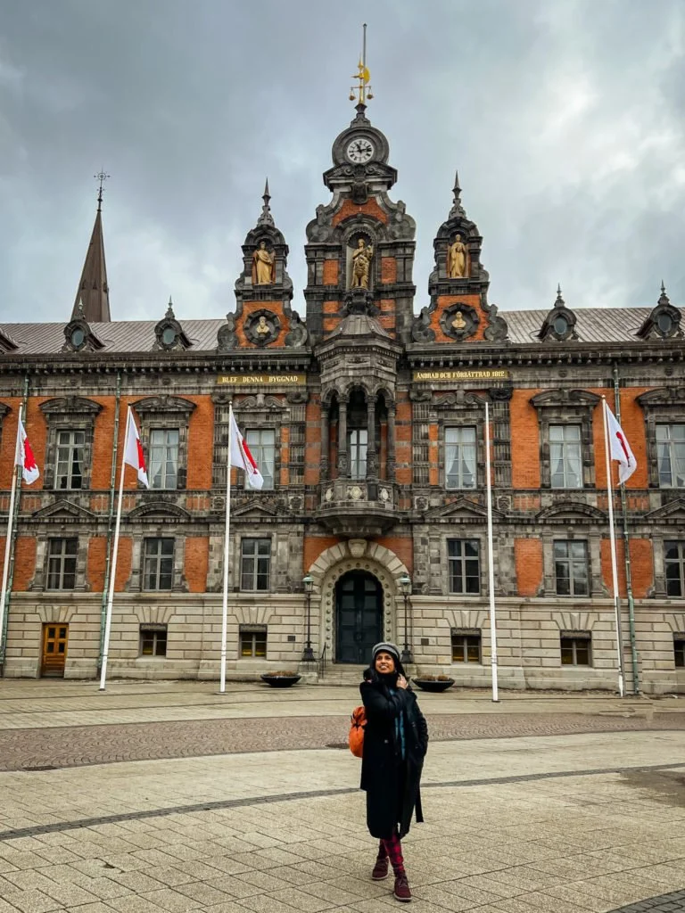 Kiki from RooKiExplorers walking in front of the town hall in Malmo.