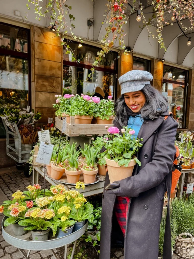 Kiki from RooKiExplorers posing with a flower pot outside a plant boutique in Malmo.