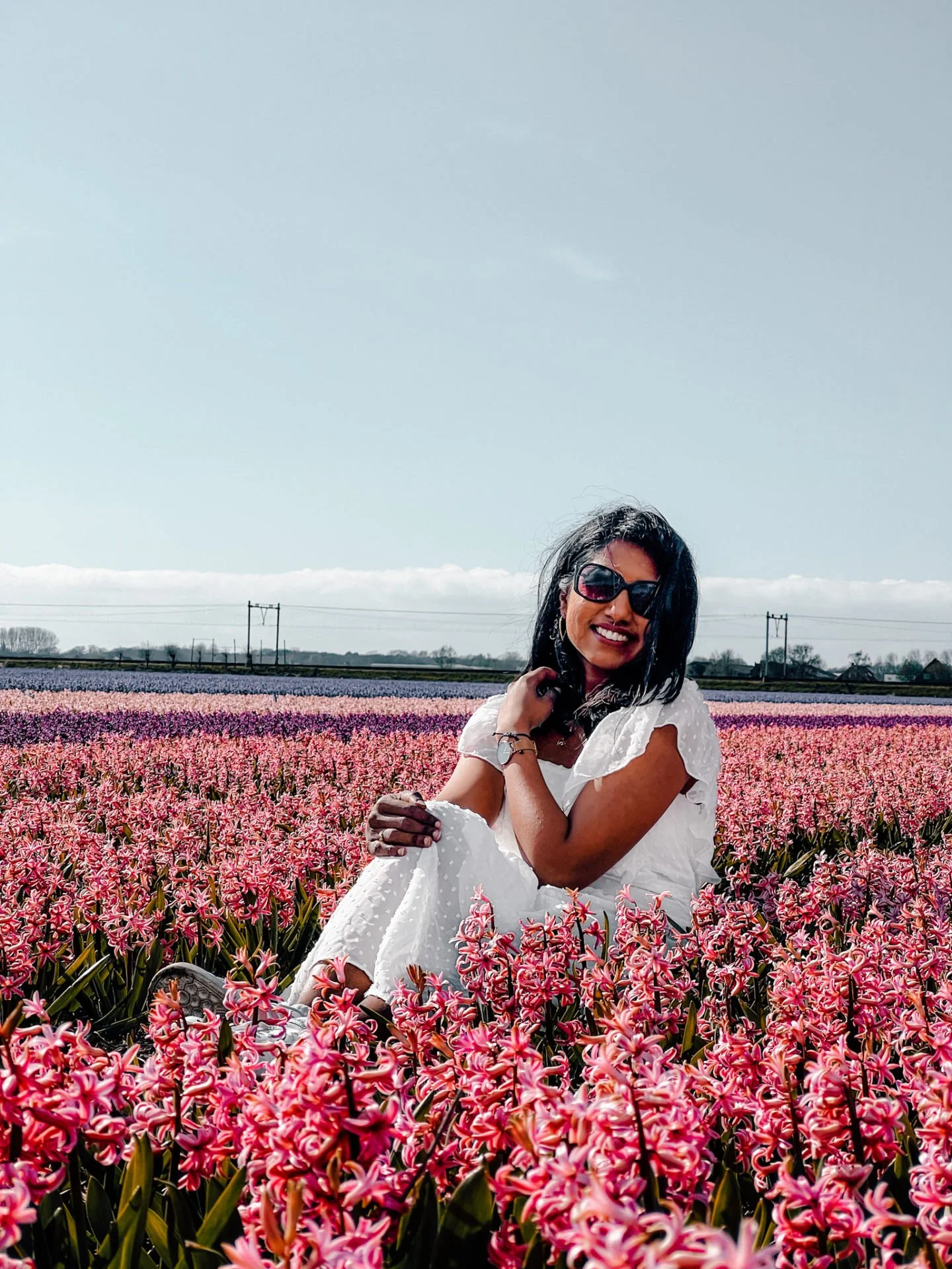 Kiki from RooKiExplorers posing in a field of pink hyacinths in the Netherlands.