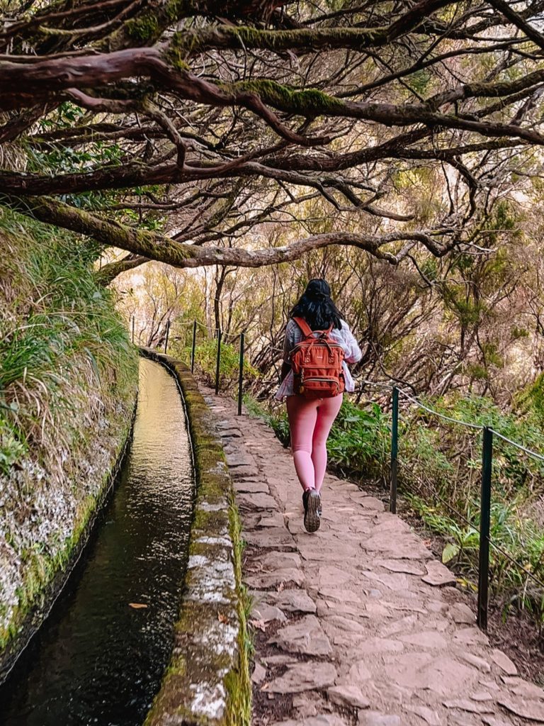 Kiki from RooKiExplorers walking near a levada during the 25 Fontes and Risco waterfall hike in Madeira.
