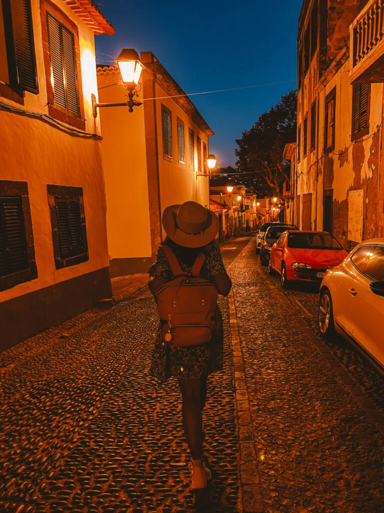 Kiki from RooKiExplorers strolling in Funchal's old town during blue hour.