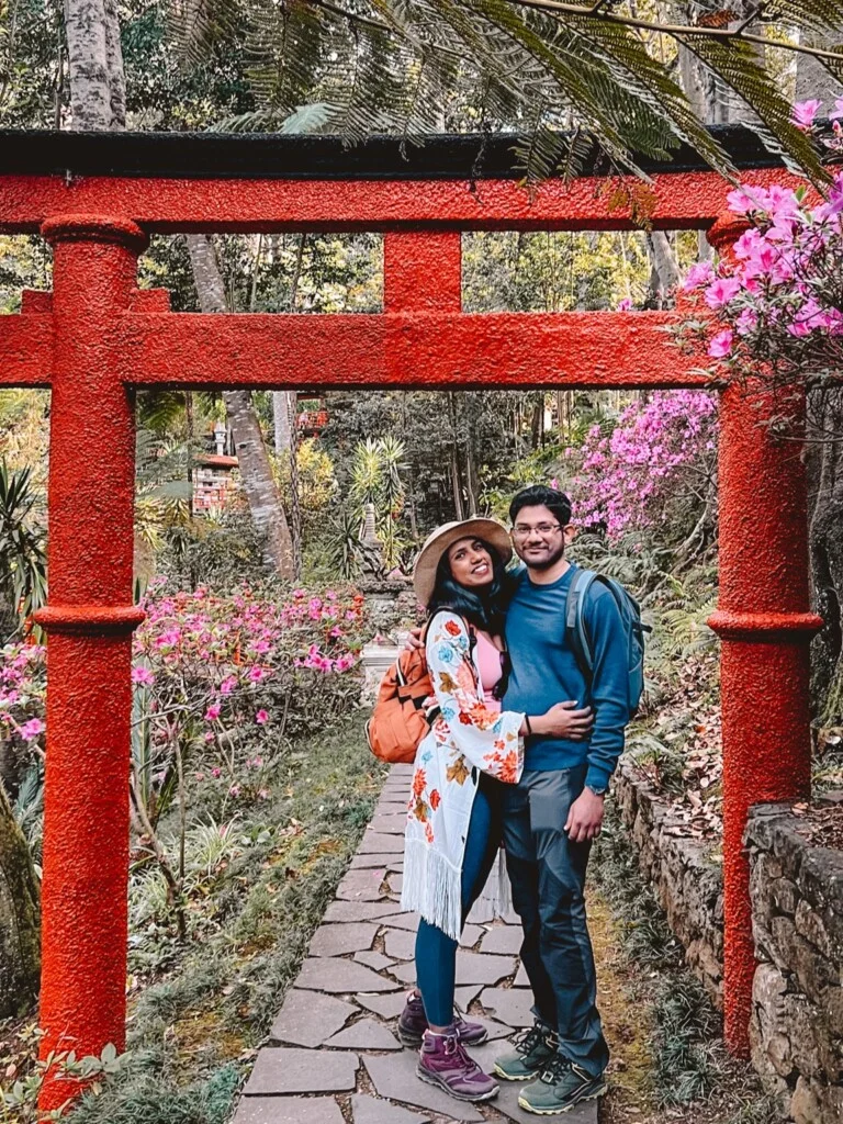 Roopesh and Kiki from RooKiExplorers posing under a Japanese traditional arch in Monte Palace Garden in Funchal.