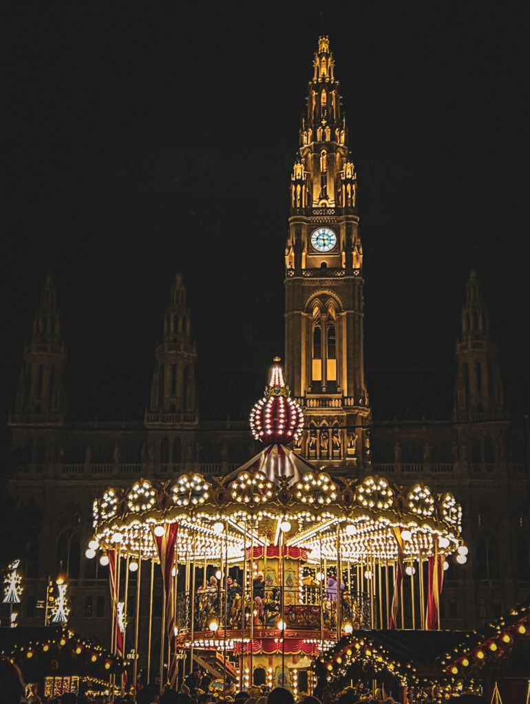 The town hall and carousel at night in Rathausplatz Christkindlmarkt in Vienna.