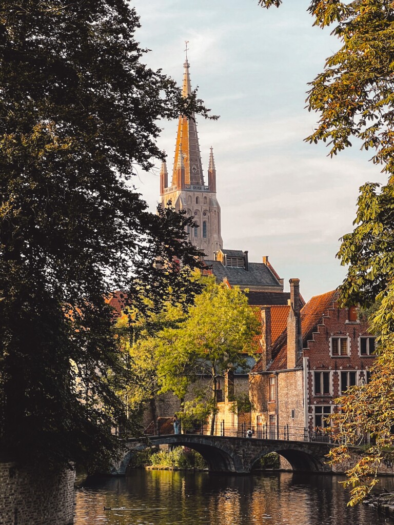 Begijnhofbrug in the foreground and the Church of Our Lady in the background in Bruges, Belgium.
