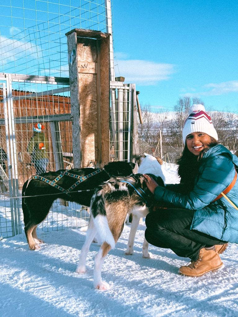 Kiki from RooKiExplorers posing with a couple of sledge dogs in Abisko.