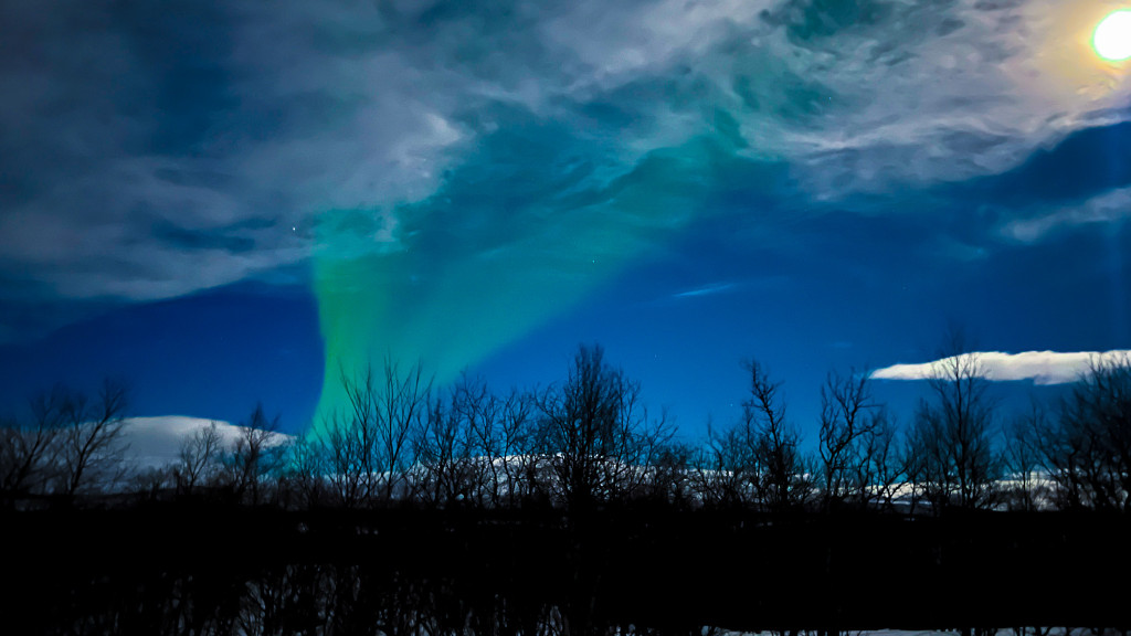 The Northern Lights between Abisko and Kiruna with the Moon.