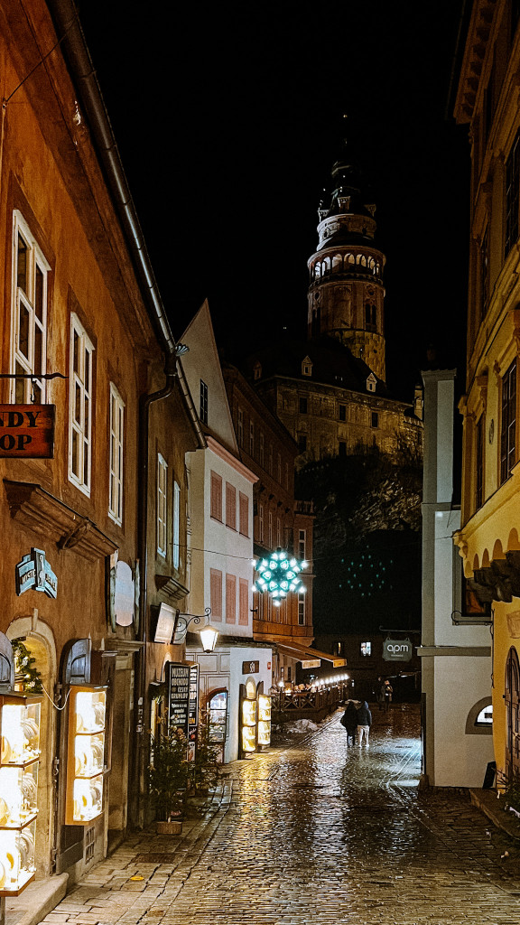 Radniční street in Český Krumlov with Christmas lights and Český Krumlov's castle in the background.